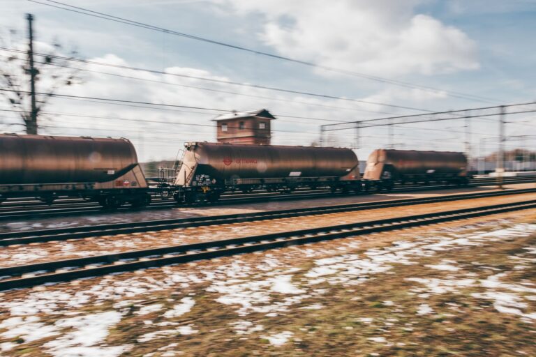 Rail Freight Volume Slump Signals Deeper Industrial Demand Weakness A long freight train traveling through an industrial landscape, representing rail cargo volume trends
