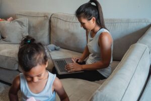 A working mother balancing childcare and remote work at home