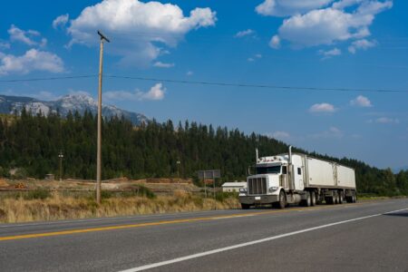 Freight Broker Margins Collapse as Shipper Direct Contracts Expand Semi truck driving on a highway representing freight transportation industry