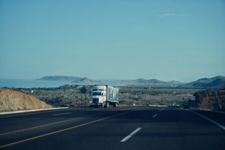 A semi-truck driving on a highway representing the trucking freight industry