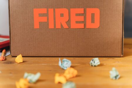 Severance Package Costs Quietly Climb as White-Collar Layoffs Spread Empty office desk with a cardboard box suggesting a recent employee layoff