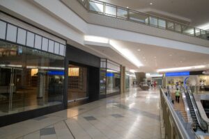 Retail Foot Traffic Slump Deepens as Consumer Confidence Cracks Empty shopping mall corridor with few shoppers and vacant storefronts