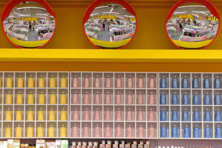 Wide aisle inside a warehouse club store stocked with bulk goods and pallets