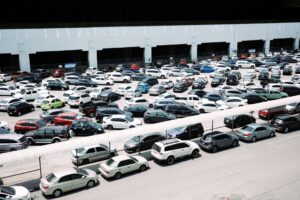 Used Car Loan Delinquencies Spike as Subprime Auto Market Cracks Rows of used cars on a dealership lot under bright sunlight