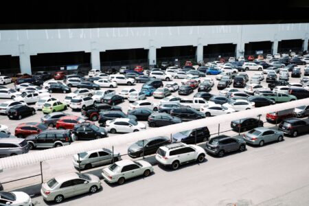 Used Car Loan Delinquencies Spike as Subprime Auto Market Cracks Rows of used cars on a dealership lot under bright sunlight