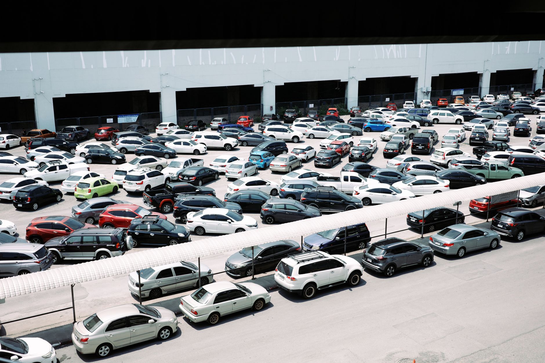 Rows of used cars on a dealership lot under bright sunlight