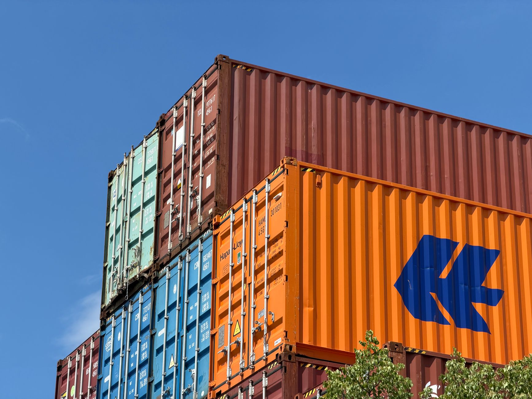 Shipping containers stacked at a commercial port reflecting softening import freight volumes