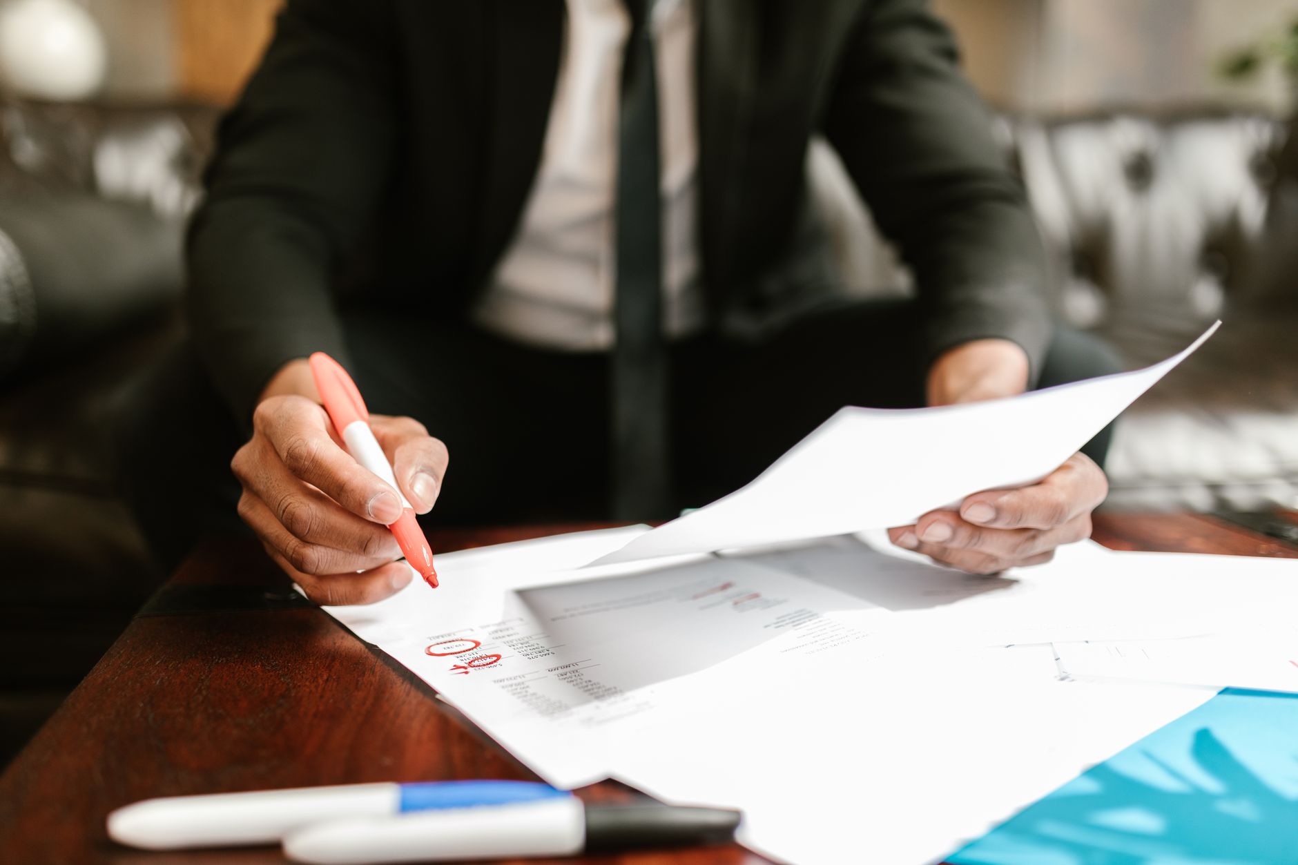 Business professional reviewing financial documents and contracts at a desk