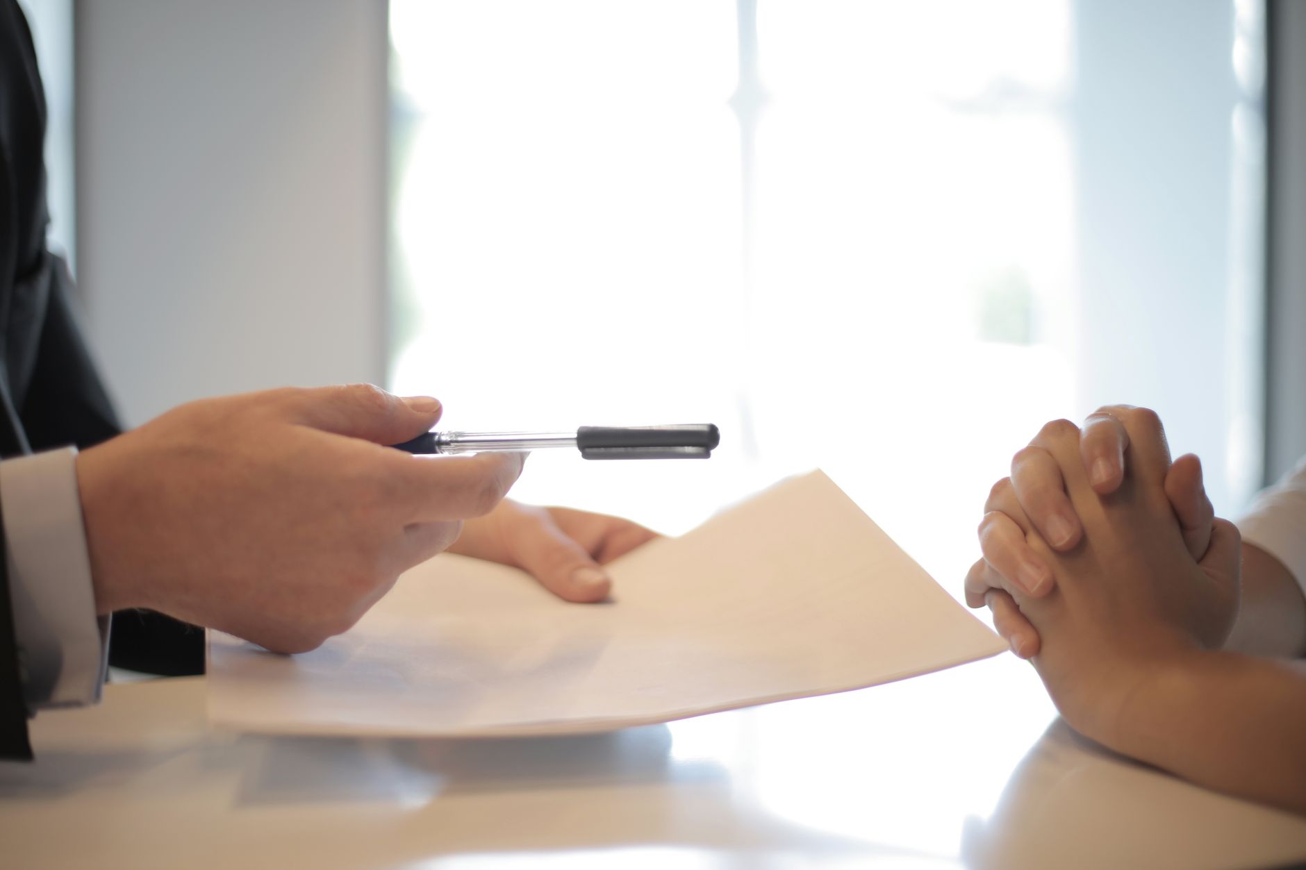Financial documents and a pen on a desk representing auto loan paperwork