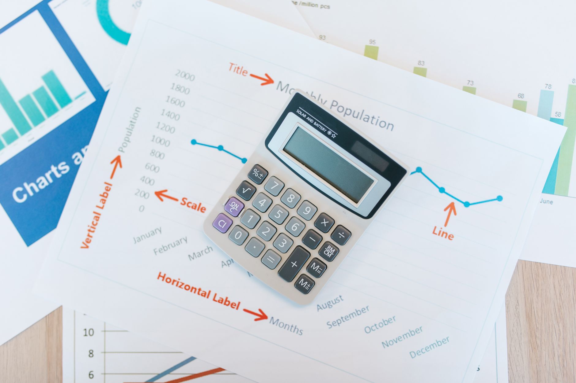 Financial analyst reviewing bond rating charts and municipal credit data at a desk