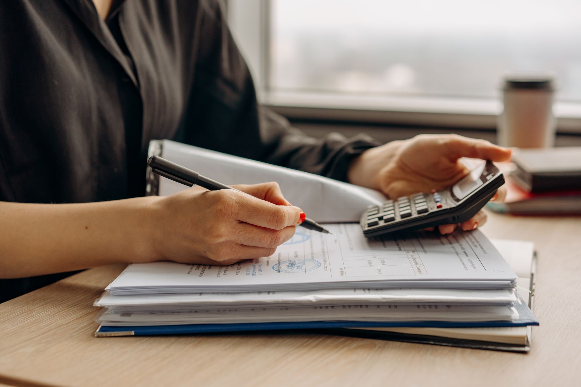Financial documents and budget spreadsheets spread across a desk representing pension cost analysis