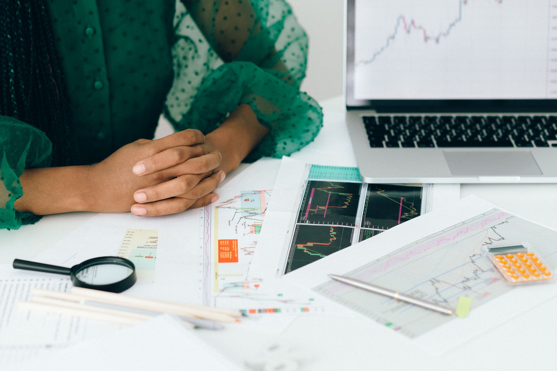 Financial broker analyzing renewable energy investment data at a desk with multiple screens