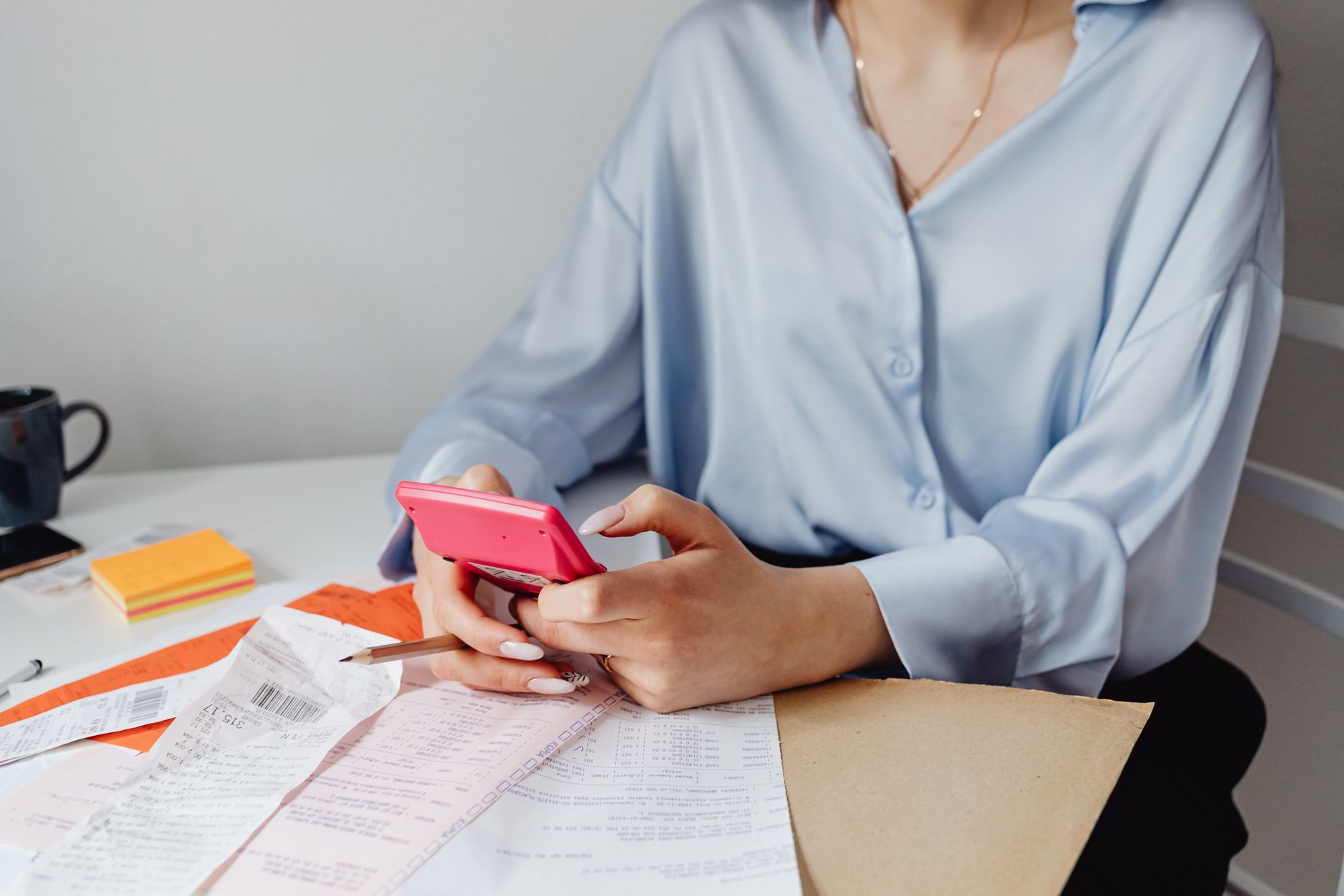 A woman reviewing financial documents and budget paperwork at a table