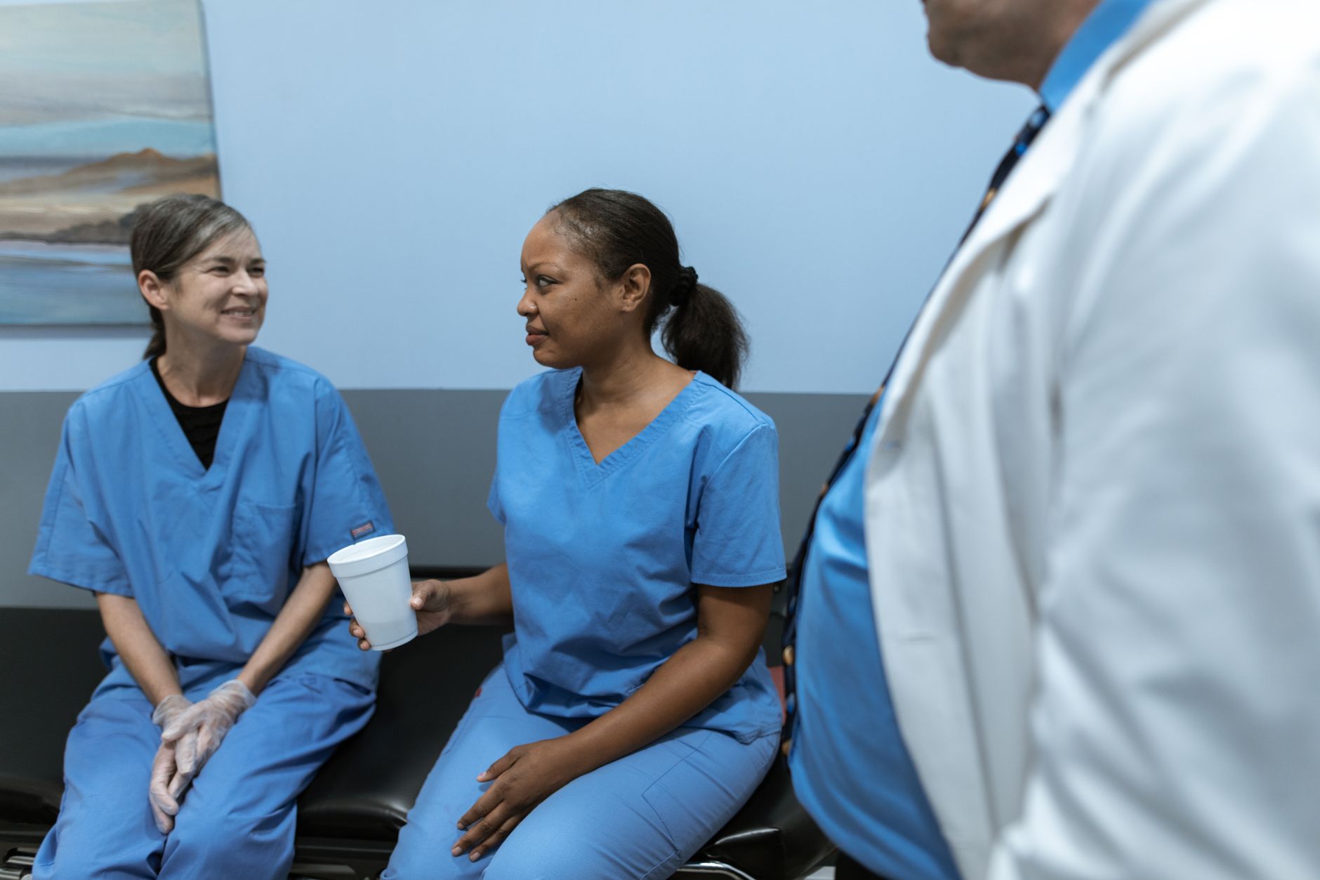 Nurse practitioner consulting with a patient in a small clinic examination room