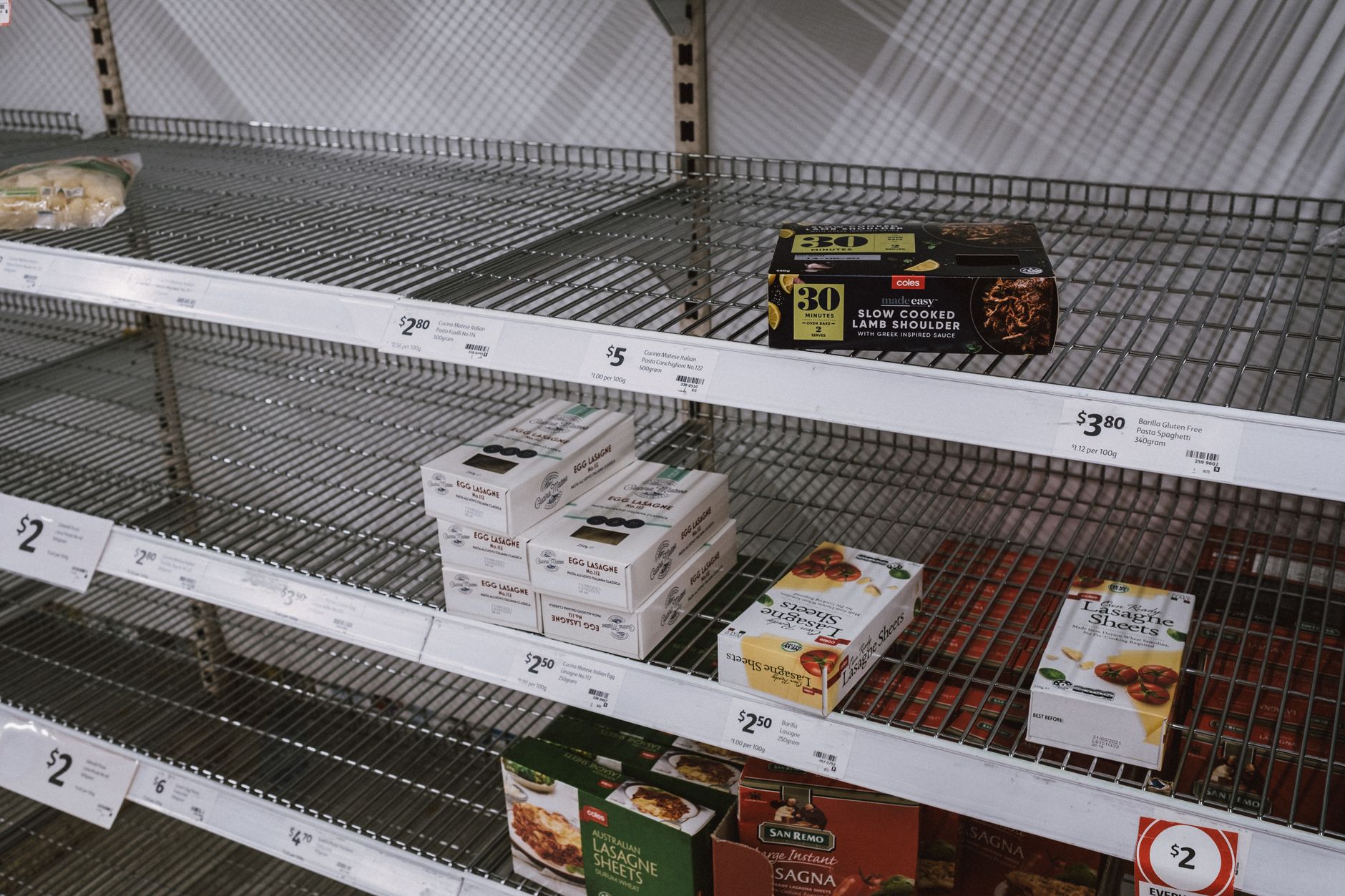 Partially empty shelves in a grocery store aisle