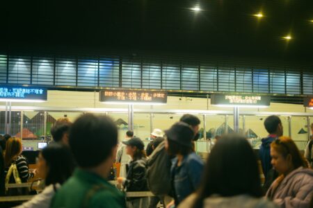 A long line of people waiting outside a government building for rental assistance
