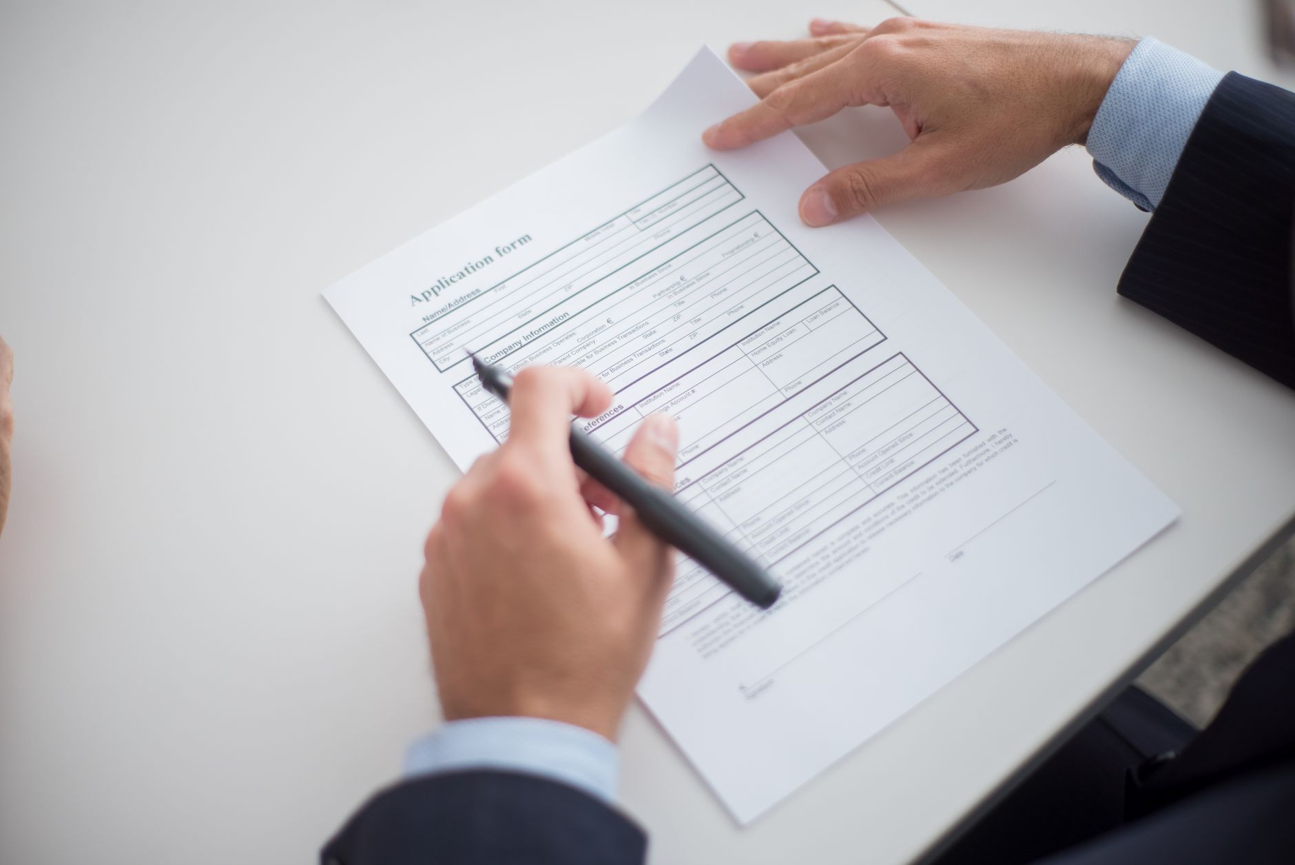 A rental application form on a desk with a pen, representing the tenant screening process