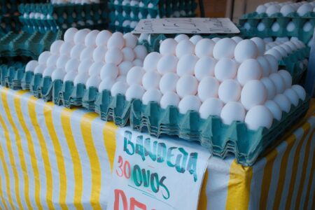 Cartons of eggs stacked on a grocery store shelf, illustrating tight egg supply and rising retail prices