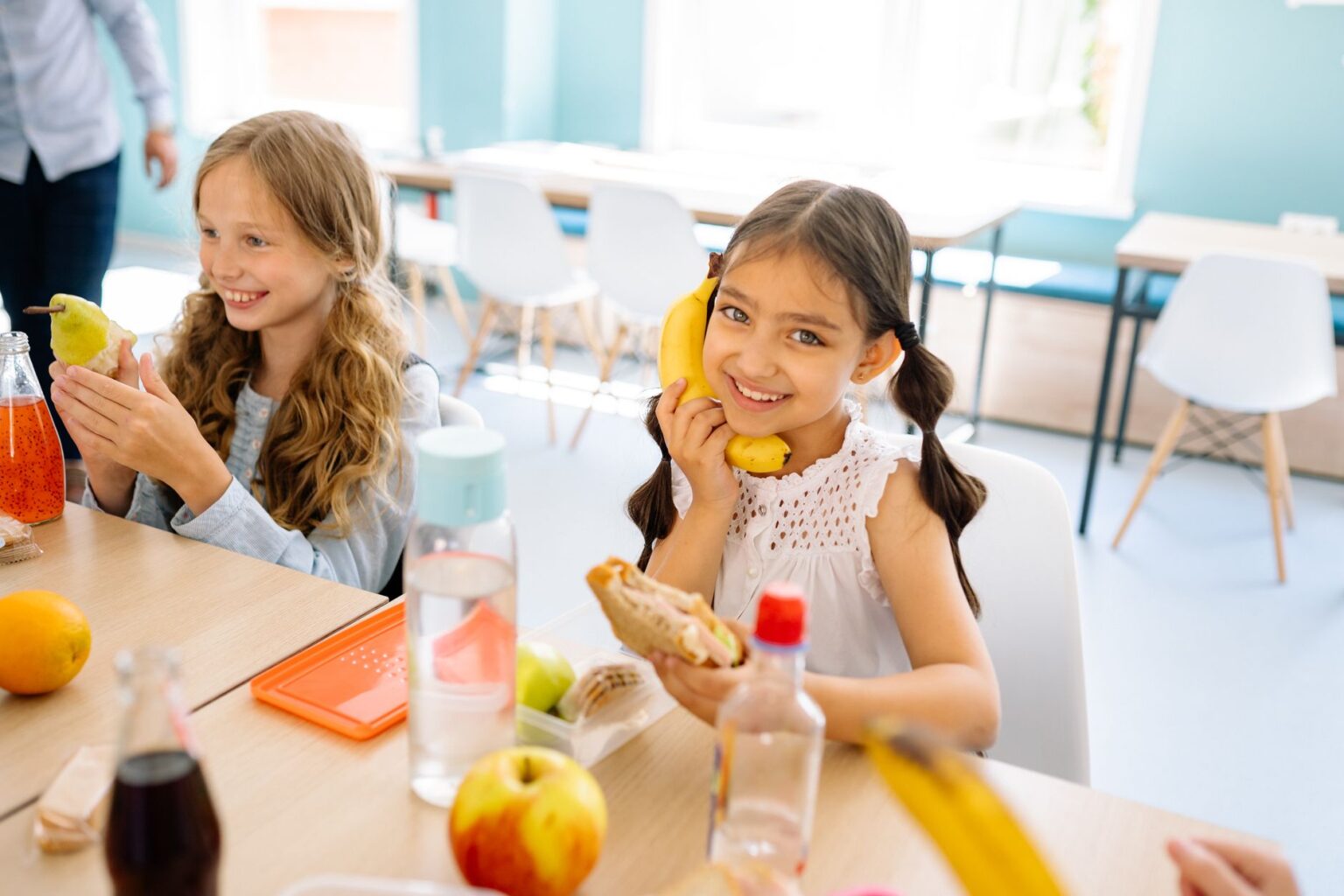 Child Nutrition Waivers Expire as School District Meal Debt Mounts Students moving through a school cafeteria lunch line with trays of food