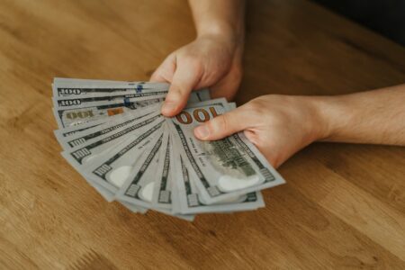 Payday Loan Rollover Restrictions Quietly Tighten as State Budgets Strain Stack of cash next to loan documents on a desk representing payday lending
