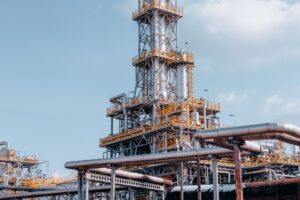 Large oil refinery with industrial towers and pipes at dusk
