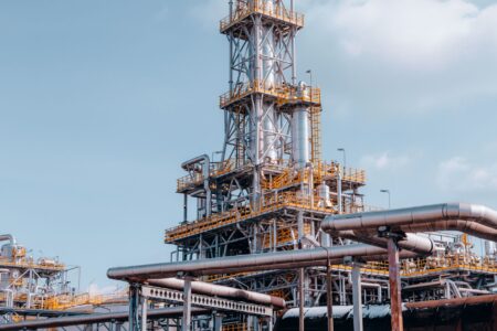 Large oil refinery with industrial towers and pipes at dusk