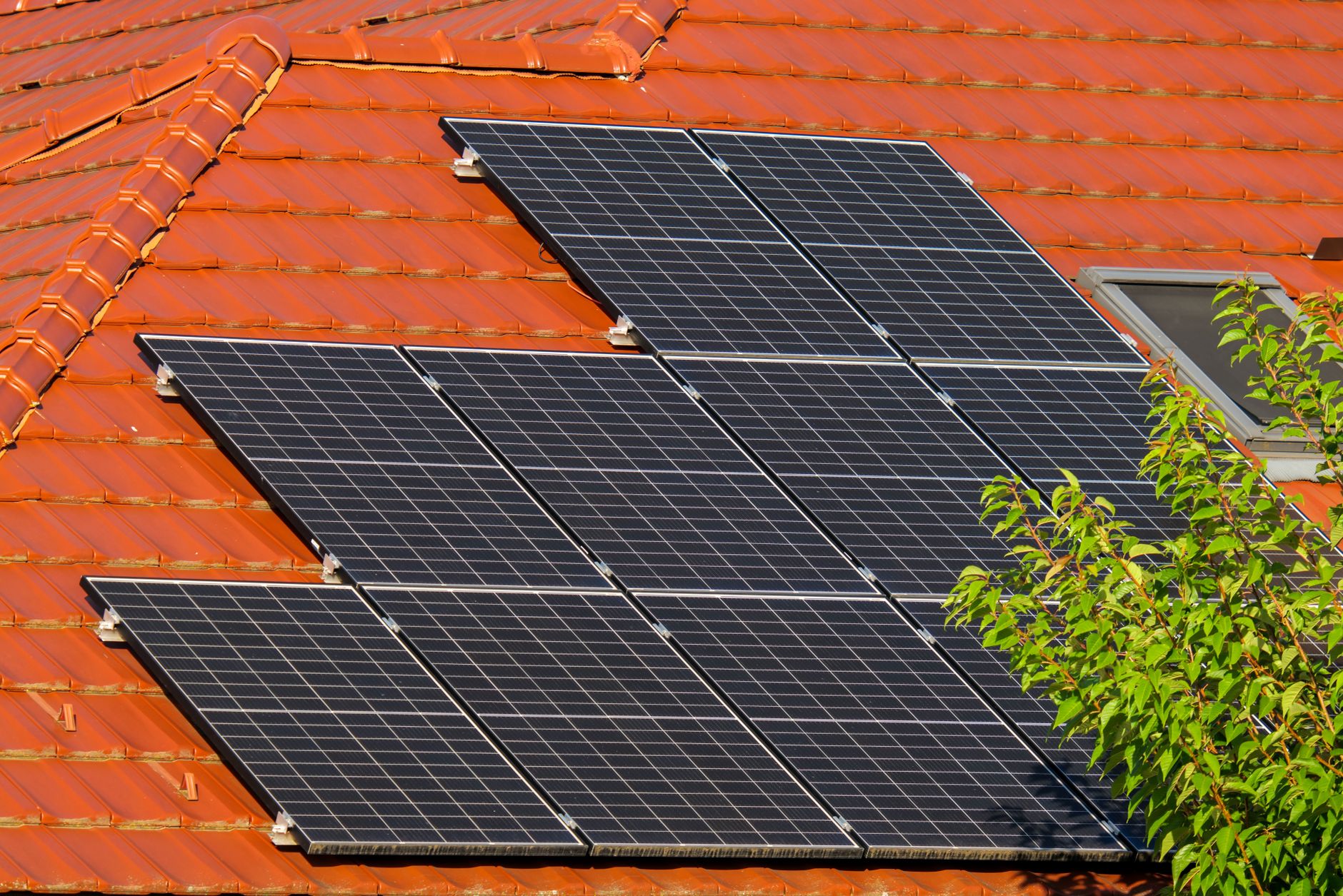 Residential solar panels installed on a suburban rooftop under clear sky