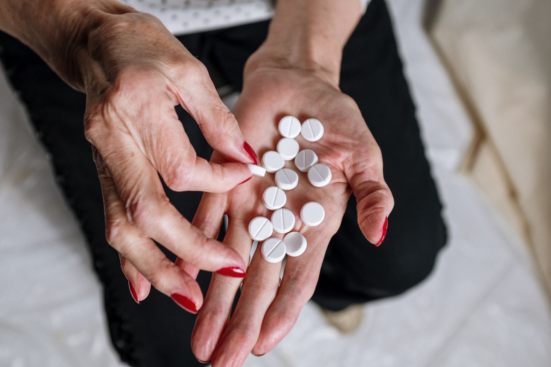 Elderly person reviewing prescription medication bottles at home