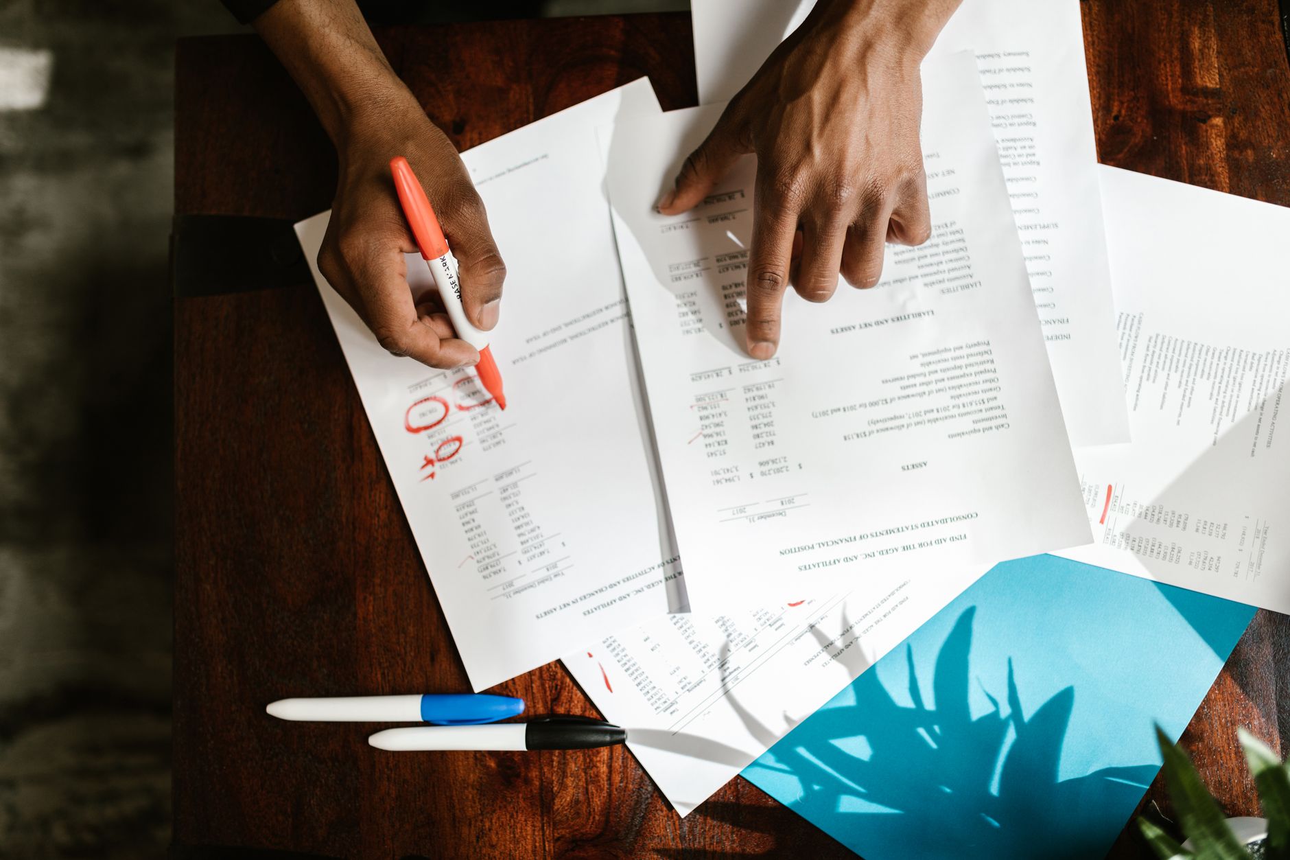Financial documents and budget reports spread across an office desk