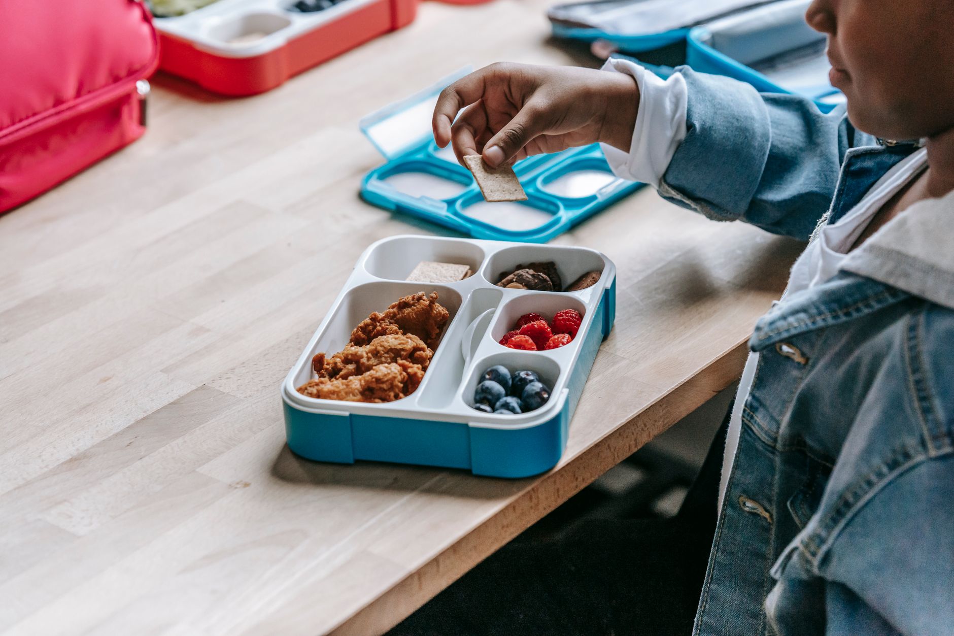 Young student eating a school lunch at a cafeteria table