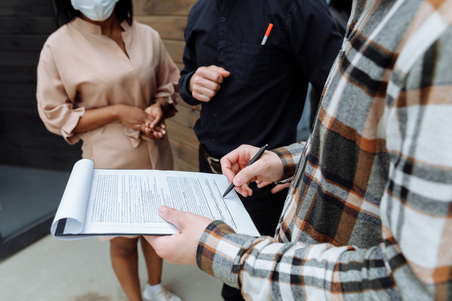 Person signing a rental contract at a desk with documents spread out