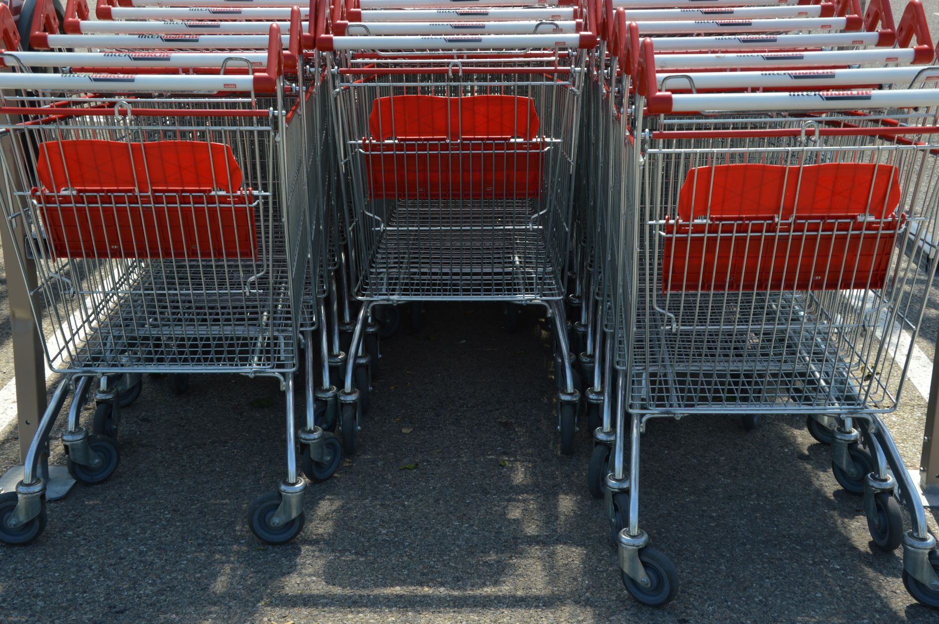Shopper pushing a cart through a grocery store aisle examining product labels