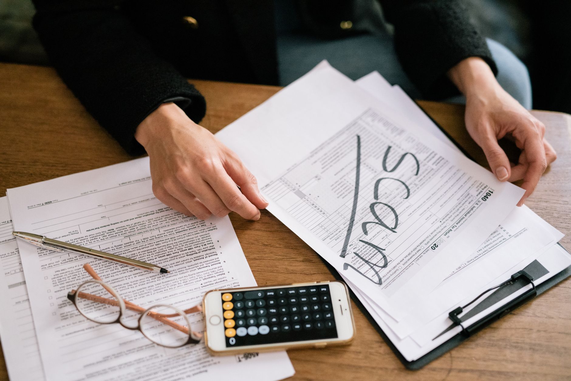 Healthcare administrator reviewing financial documents and audit paperwork at a desk