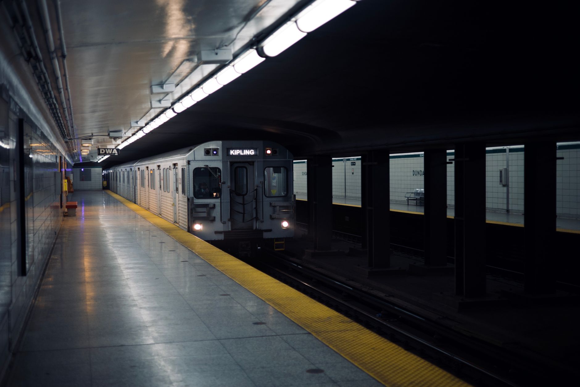 Workers performing maintenance and repair work inside an aging subway station