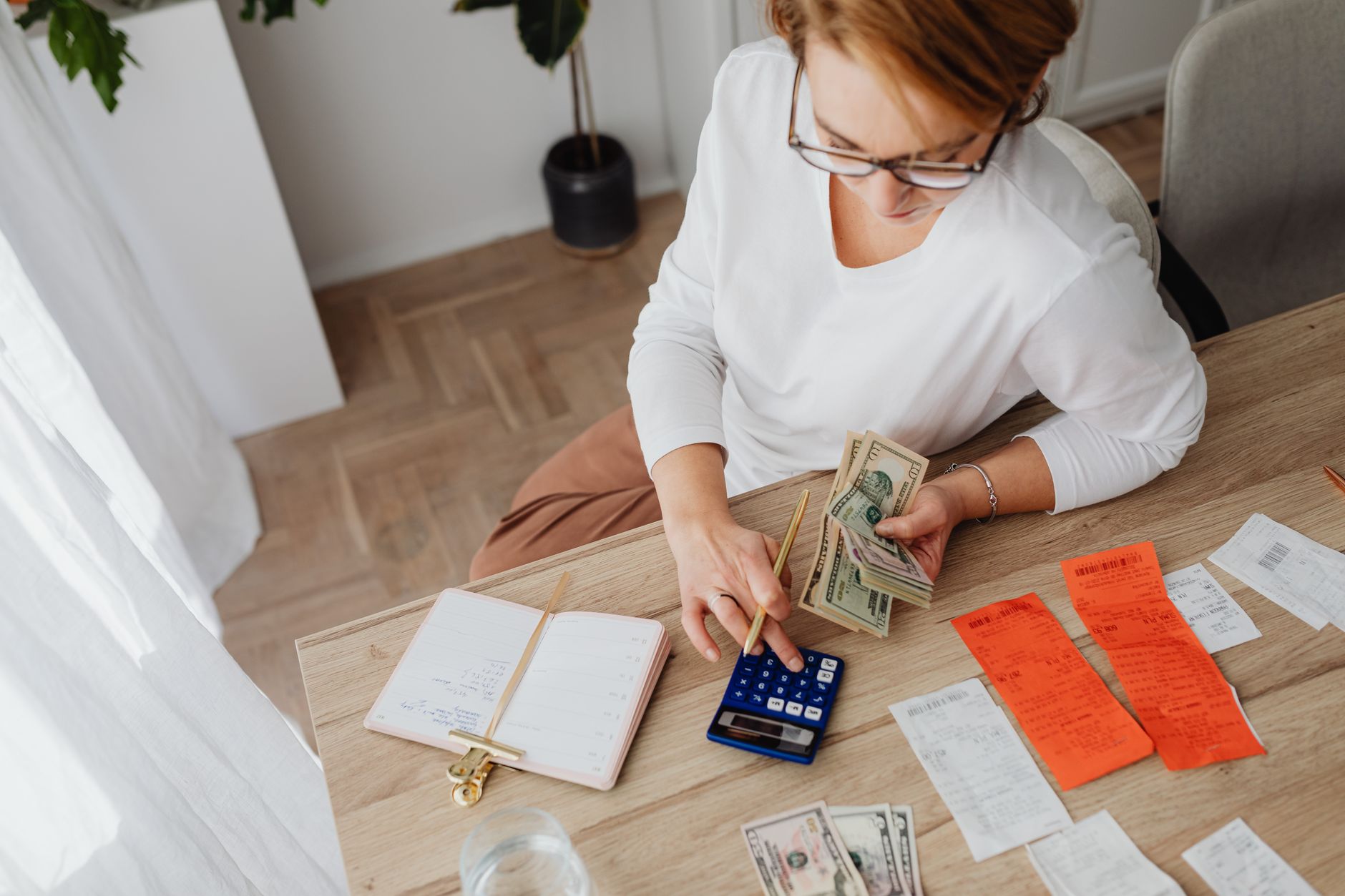 Person reviewing financial documents and bills at a kitchen table